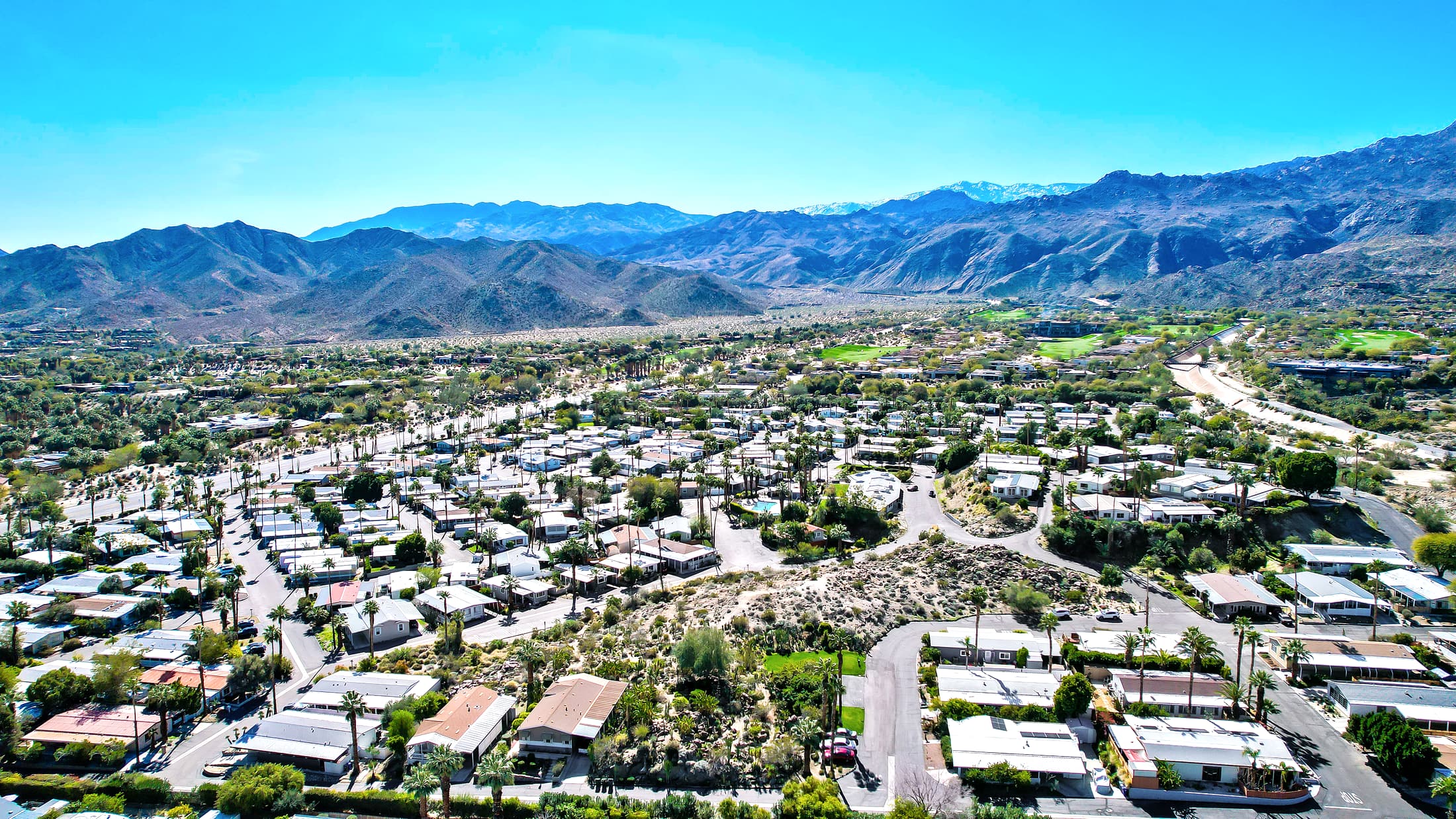 Aerial view of Silver Spur manufactured home community framed by mountains in Palm Desert